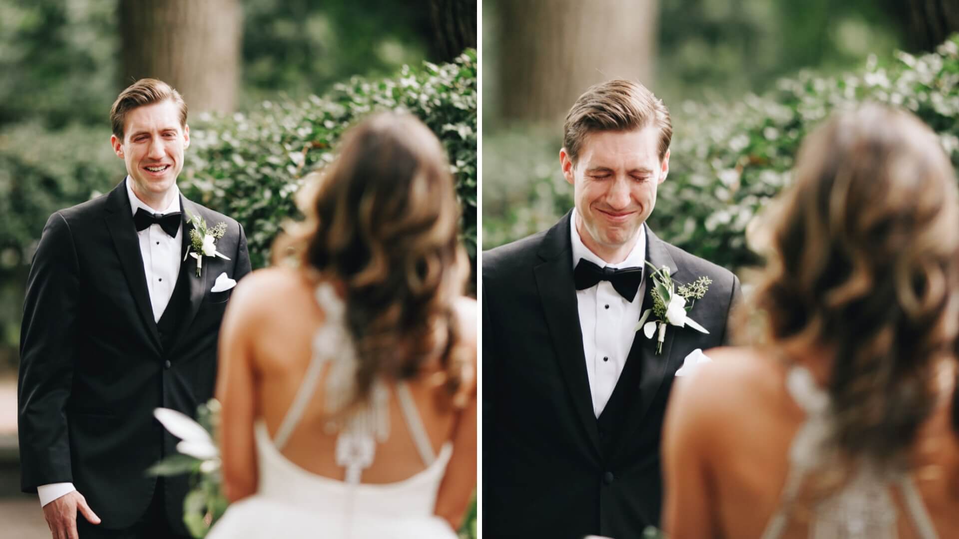 Couple facing each other outdoors. The groom is in a black tuxedo with a bow tie, and the bride is in a white dress with an intricate back design. Both appear emotional.