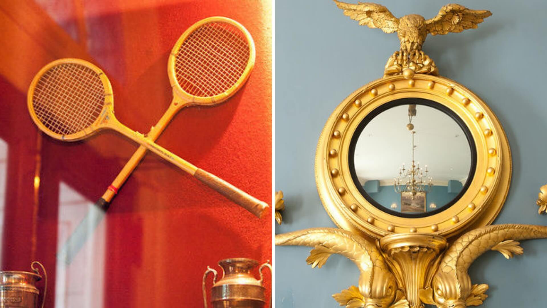 Two vintage wooden tennis rackets crossed over each other on a red background; adjacent is a round, gold-framed mirror with an eagle decoration on top against a blue wall.